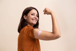 Mulher mostrando o braço vacinado.